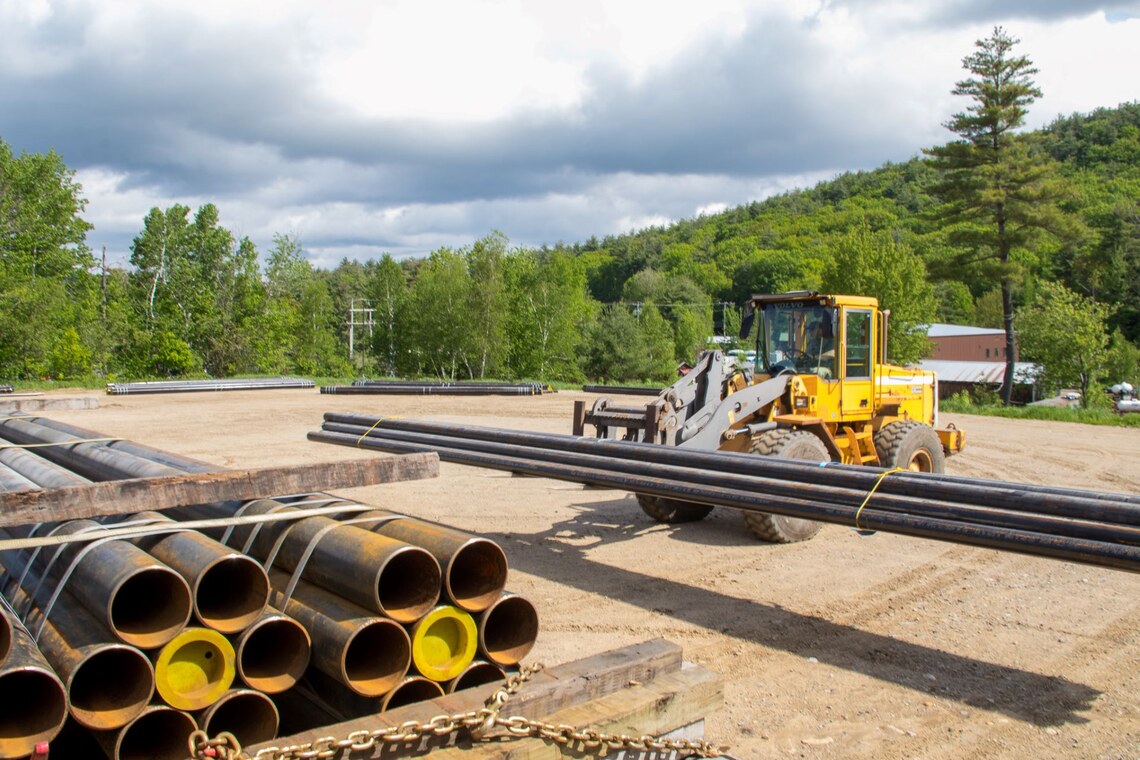 Snowmaking pipe being unloaded from a flatbed truck